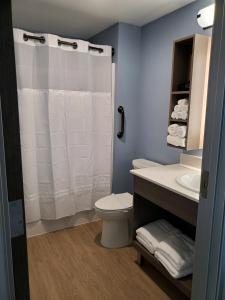 a bathroom with a white shower curtain and a toilet at salish Inn in Anacortes