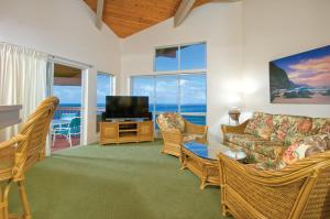 a living room with a couch and a television at Club Wyndham Shearwater in Princeville