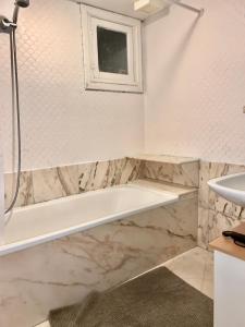 bagno con vasca e lavandino di Cocoon - Duplex 3 chambres 140 m2 a Bruxelles