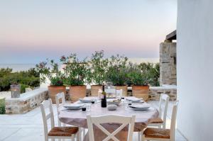 a table and chairs on a patio with plants at VILLA SOROS in Antiparos +8 photos