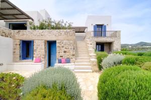 a stone house with blue doors and pink pillows at VILLA SOROS in Antiparos