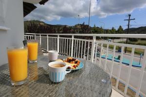 a table with a plate of food and two glasses of orange juice at Mare Monte Luxury Apartments 2 in Nea Skioni