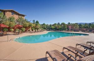 a swimming pool with benches and tables in a resort at Club Wyndham Sedona in Sedona