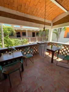 a patio with tables and chairs and a hammock at Hosteria Chata Adults Only in Lo de Marcos