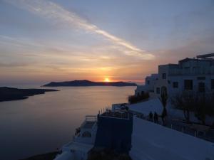 a sunset over the water on the side of a building at NONI STUDIOS in Fira