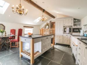 uma grande cozinha com armários brancos e uma mesa em Glanville House em Mevagissey