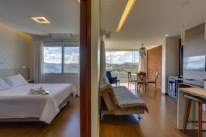 Cet appartement comprend une chambre avec un lit et une cuisine avec une table. dans l'établissement Pousada Janela do Vale, à Nova Petrópolis