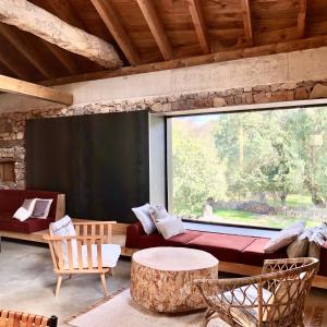 uma sala de estar com uma grande janela e um sofá em El pajar de abajo - Pedraza - em La Alameda