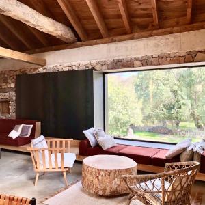 a living room with a large window and a couch at El pajar de abajo - Pedraza - in La Alameda