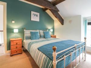 ドルゲラウにあるBryn Meirion Bachのベッドルーム1室(青い壁のベッド1台付)