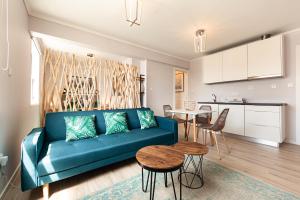 a living room with a blue couch and a table at Pico Studios in Madalena