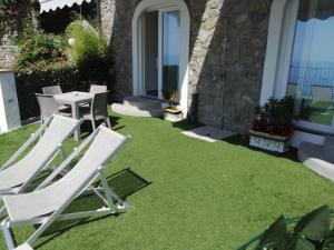 a group of lawn chairs and a table on a lawn at Gresy Appartamento Suite in Positano