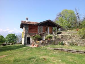 a small stone house on a grassy field at Il Ciliegio Selvatico in Verbania