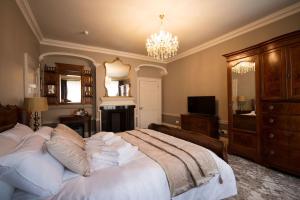a bedroom with a large white bed with a chandelier at East Walls Hotel in Chichester