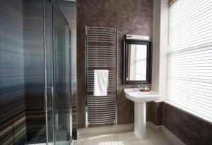 a bathroom with a sink and a glass shower at East Walls Hotel in Chichester