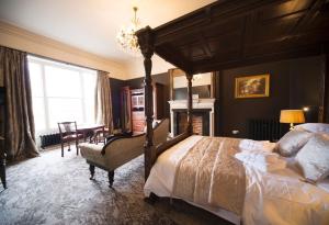 a bedroom with a canopy bed and a fireplace at East Walls Hotel in Chichester