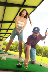 een man en een vrouw die een spelletje golf spelen bij Xaha Villas Suites & Golf Resort in Tulum