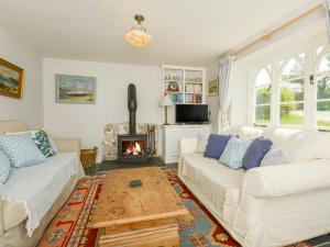 a living room with two white couches and a fireplace at Chapel Cottage in Bideford