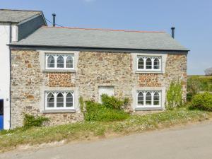 una casa de ladrillo con ventanas blancas en una calle en Chapel Cottage en Bideford