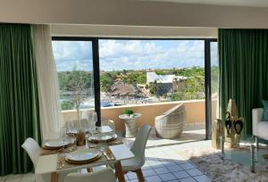 une salle à manger avec une table et une grande fenêtre dans l'établissement Colibri Paradise Puerto Aventuras, à Puerto Aventuras