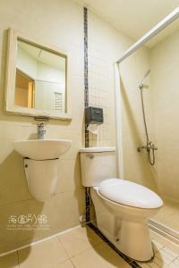 a bathroom with a toilet and a sink and a mirror at 墾丁海園別館Hai Yuan Inn in Kenting