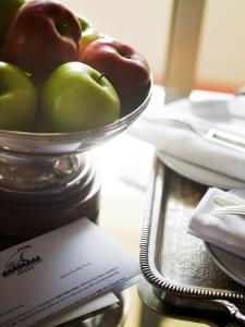 a bowl of apples on a table with a card at Hôtel Belles Rives in Juan-les-Pins