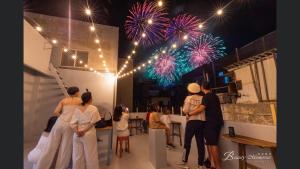 a group of people standing in a room with fireworks at Nice Hostel in Magong