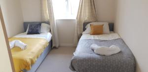 two beds in a small room with two bedsskirts at Hobart Apartment Chelmsford in Chelmsford