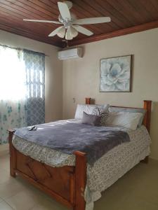 a bedroom with a bed with a ceiling fan at Fishtails Palms - Tamarind in Stuart Manor