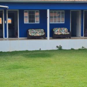 a blue house with two seats on the porch at Pousada Cachoeiras do Jalapão in São Félix do Tocantins