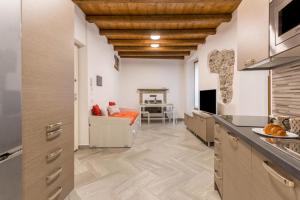 Il comprend une cuisine avec des murs blancs et des plafonds en bois. dans l'établissement COTTAGE GIULIA, à Argegno