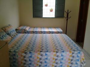 1 dormitorio con 1 cama con un edredón colorido en Casa - Chácara Bella Arraes, en Bauru