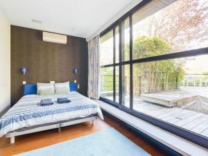 ein Schlafzimmer mit einem Bett und einem großen Fenster in der Unterkunft Picturesque villa in Bierges with swimming pool and barbeque in Bierges