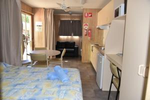 um quarto com uma cama, uma cozinha e uma mesa em Ball Park Caravan Park em Corowa