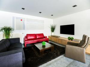 ein Wohnzimmer mit 2 Sofas und einem Flachbild-TV in der Unterkunft Classy Apartment in Weelde with Swimming Pool in Weelde