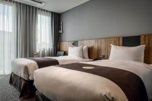 a hotel room with two beds and a window at Best Western Plus Hotel Sejong in Sejong