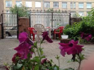 a patio with a table and chairs and purple flowers at Mumi Troll in Saint Petersburg