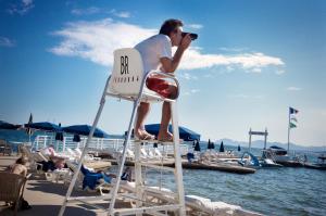 a man sitting in a chair on the beach at Hôtel Belles Rives in Juan-les-Pins