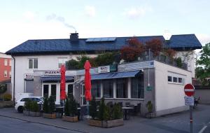 un restaurante con sombrillas rojas frente a un edificio en Haus Edith Privathaus mit Gästezimmern, en Bregenz