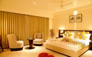 NadiādHOTEL CYPRESS的一间卧室，里面有一张床、两把椅子和一张桌子