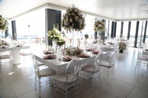 une salle à manger blanche avec une grande table et des chaises dans l'établissement Blueberry Hill Hotel, à Roodepoort