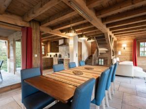 a dining room with a wooden table and blue chairs at Chalet La Clusaz, 5 pièces, 8 personnes - FR-1-304-110 in La Clusaz