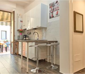 a kitchen with white cabinets and a counter with stools at Residenza Martin in Florence