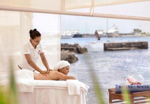 a woman sitting in a bath tub with a masseur at Hôtel Belles Rives in Juan-les-Pins
