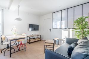 sala de estar con sofá y mesa en Welcome perche ! Appartements 3 étoiles à NOGENT le Rotrou en Nogent-le-Rotrou