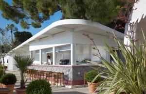 a white building with chairs in front of it at Hôtel Belles Rives in Juan-les-Pins