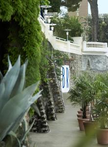 a stone wall with plants and a sign on it at Hôtel Belles Rives in Juan-les-Pins