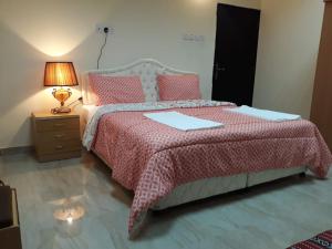 a bedroom with a bed with a red blanket and a lamp at Ahlam Musandam Villa in Khasab