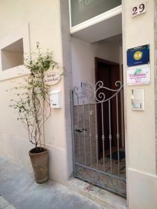 um portão em frente a um edifício com uma planta em Il gelsomino em Scicli
