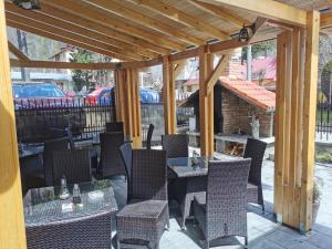 a patio with tables and chairs and a fireplace at Pensiunea Memy in Buşteni